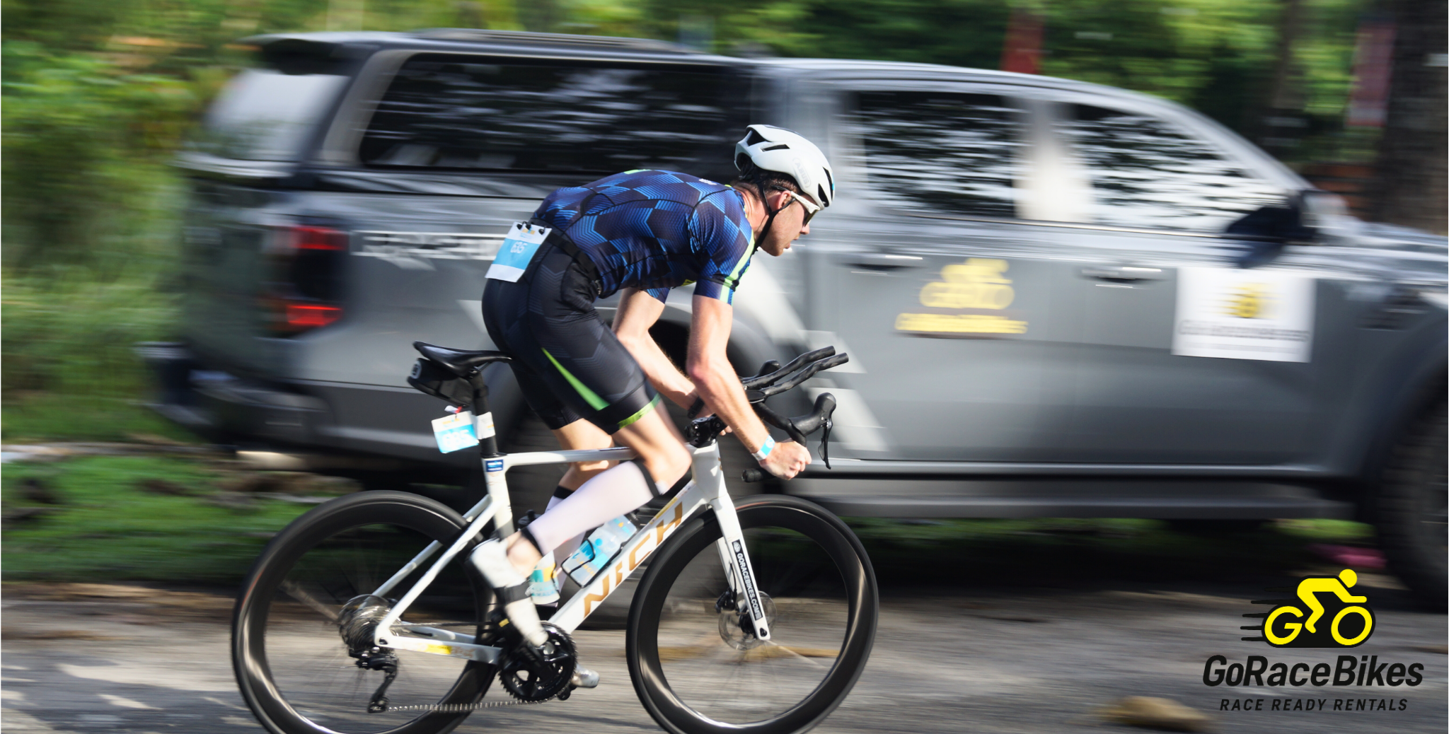 Male triathlete racing on a white aero triathlon bike rental from GoRaceBikes in Malaysia.